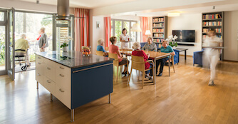 Foto des hellen und offenen Wohnbereiches mit Personal des Alten- und Pflegeheim LANDHAUS Pflege & Wohnen